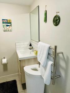 a bathroom with a white toilet and a sink at Whitby Studio - Mairangi Bay Beach in Auckland +62 photos