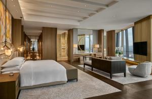 a bedroom with a bed and a desk and a television at Park Hyatt Kuala Lumpur in Kuala Lumpur