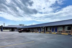 a building with a car parked in a parking lot at Travelodge by Wyndham Thomasville AL in Thomasville