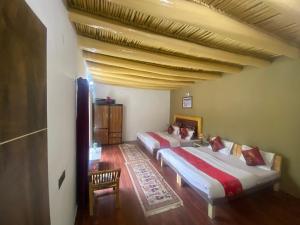 two beds in a room with a wooden ceiling at The shore in Hundar