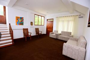 a living room with a couch and chairs and a table at Lush Home in Bandarawela +4 photos