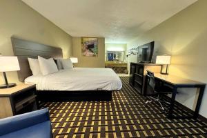a hotel room with a bed and a desk and a computer at Travelodge by Wyndham Thomasville AL in Thomasville +77 photos