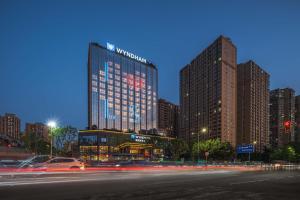 a city with tall buildings and cars on a street at Wyndham Leshan Downtown in Leshan