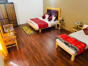 a bedroom with two beds and wooden floors at The shore in Hundar