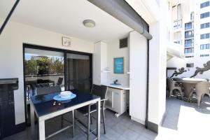 an apartment with a balcony with a desk and a table at Barefoot Bliss in Rockingham