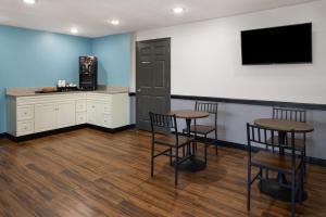 a bar with two stools and a tv on a wall at Days Inn by Wyndham Moosic in Moosic