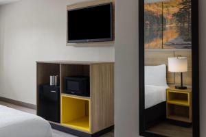 a hotel room with a tv and a bed at Days Inn by Wyndham Moosic in Moosic