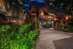 an entrance to a resort with signs and plants at Tam Coc Oasis Resort & Spa in Ninh Binh