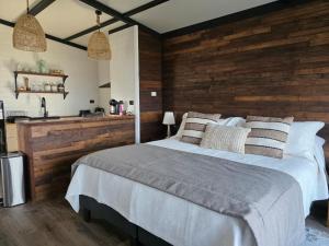 a bedroom with a large bed with a wooden wall at Cabañas AlSur Patagonia in Puerto Natales