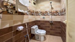 a bathroom with a toilet in a tiled wall at قصر لوماج - احد رفيدة in Ahad Rafidah +53 photos