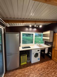 a kitchen with a refrigerator and a washing machine at Razna Lake House in Astici