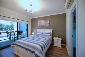 a bedroom with a bed and a dining room at Barefoot Bliss in Rockingham +8 photos