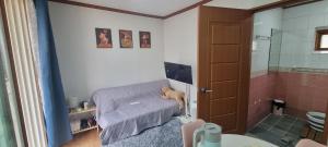 a bathroom with a bed with a teddy bear sitting on it at Lunar House in Hyomoktong-Ilgu