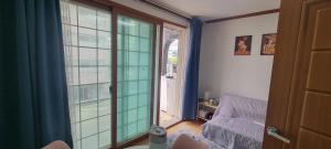 a room with a large glass window and a chair at Lunar House in Hyomoktong-Ilgu