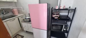 a pink refrigerator in a small kitchen with a microwave at Lunar House in Hyomoktong-Ilgu +17 photos
