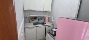 a small kitchen with a sink and a stove at Lunar House in Hyomoktong-Ilgu