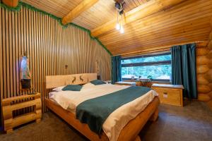 a bedroom with a bed in a log cabin at Barlogul Ursului in Baia Mare +81 photos