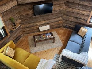 an overhead view of a living room with a couch and a tv at Villa Pukelo Arctic Lodge with wifi sauna 4 poster bed fireplace in Salla +18 photos