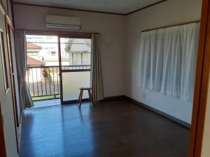 an empty room with a door and a balcony at 民宿なかやま in Kushimoto