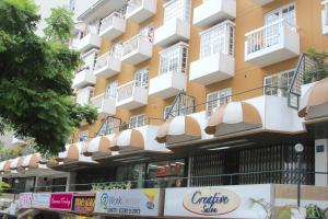 un edificio alto de color amarillo con balcones blancos en InkaHuset Miraflores, en Lima