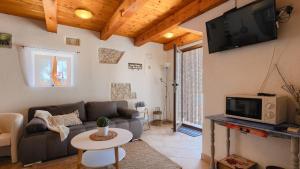 a living room with a couch and a tv at Lukini dvori by Villas Guide in Bibići