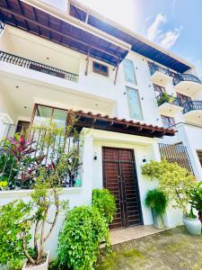 a white house with plants in front of it at Shek Residence in Colombo