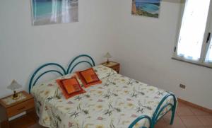 a bedroom with a bed with two books on it at Marina's apartment Ogliastra in Lotzorai