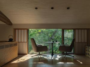 a room with two chairs and a table in front of a window at OTARU RETREAT KURAMURE by Onko Chishin in Otaru