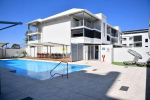 a apartment building with a swimming pool in front of it at Barefoot Bliss in Rockingham