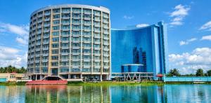 a large building next to a body of water at Crown Comfortia Hotel Jashore in Jessore