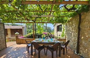 a patio with a table and chairs under a pergola at Casa rural O CARBALLO DA PEDRA in La Cañiza