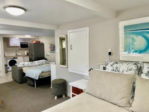 a room with two beds and a kitchen at Whitby Studio - Mairangi Bay Beach in Auckland