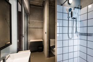 a bathroom with a shower and a sink and a toilet at Westory Design Poshtel in Kanchanaburi City +56 photos