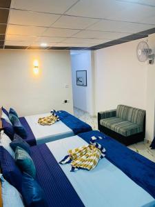 a room with two beds and a couch at Tunnel Gap Homestay in Ella