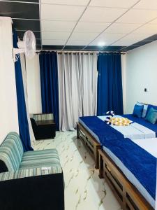 a bedroom with two beds and a chair in it at Tunnel Gap Homestay in Ella