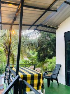 a patio with a table and chairs on a porch at Tunnel Gap Homestay in Ella +127 photos