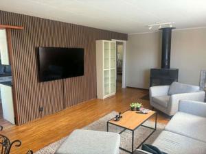 a living room with a couch and a television on a wall at Villa Konga in Konga