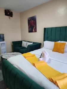 a bedroom with two beds and a couch at PiemStays in Ruaka