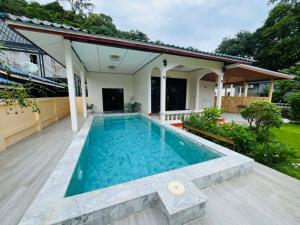 a swimming pool in the backyard of a house at Coconut hill villa in Trat