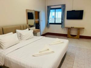 a bedroom with a white bed with two towels on it at Coconut hill villa in Trat