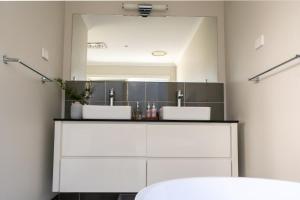 a bathroom with two sinks and a mirror at The Rye Reset in Rye +22 photos