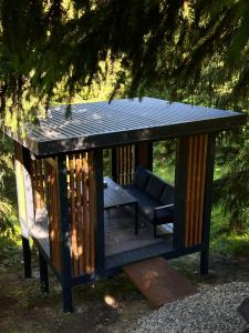 a gazebo with a couch and a table at Forest Huts in Yablunytsya +46 photos