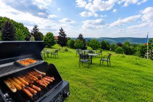 a grill with hot dogs and tables and chairs at Mikes Fewo in Hohegeiß