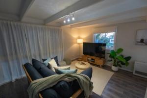 a living room with a blue couch and a tv at The Rye Reset in Rye
