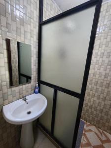 a bathroom with a sink and a glass shower door at PiemStays in Ruaka