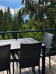 a wooden table and chairs on a wooden deck at Forest Huts in Yablunytsya