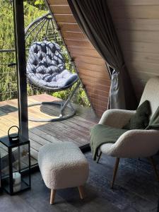 a porch with two chairs and a swing at Forest Huts in Yablunytsya