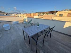 a wooden table and chairs on a roof at La casa di GiòGiò in San Vito lo Capo
