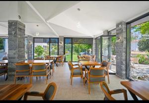 a restaurant with wooden tables and chairs and windows at Arzu otel apart in Datca +11 photos