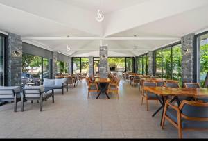 a restaurant with tables and chairs and windows at Arzu otel apart in Datca